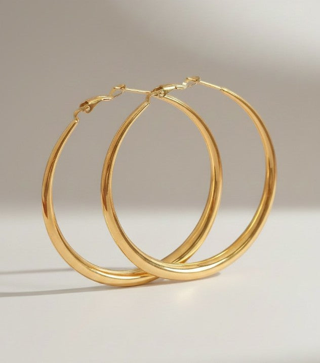 Nouvél the Label® grote gouden curve hoepeloorbellen van stainless steel met glanzende afwerking en kliksluiting.